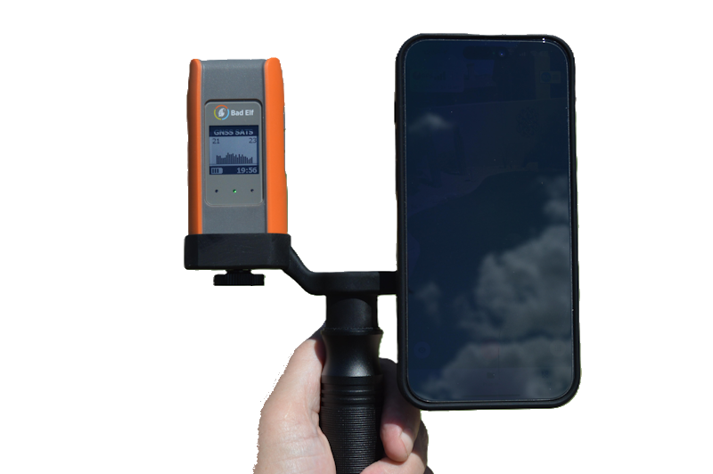 Load image into Gallery viewer, Hand holding a device with an orange and gray panel next to a smartphone on a white background
